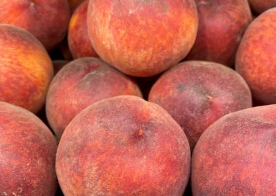 A dozen red and orange ripe peaches.